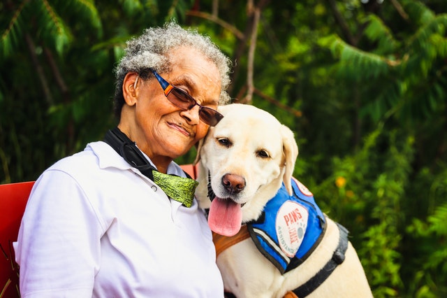older black woman poses with diabetic alert dog